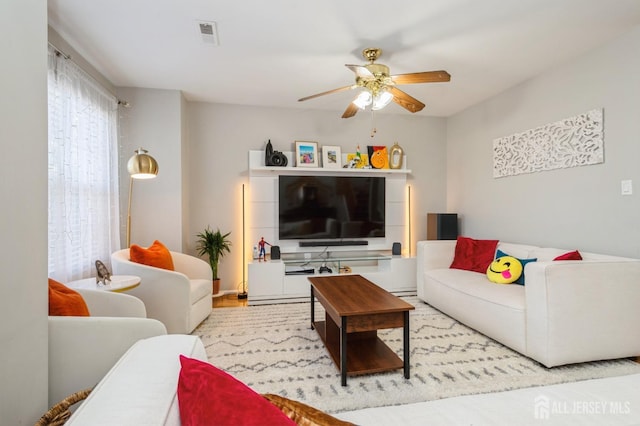 living room featuring visible vents and a ceiling fan