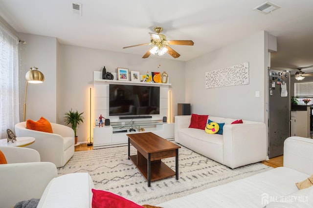 living room featuring ceiling fan and visible vents