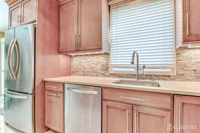 kitchen with sink, tasteful backsplash, and appliances with stainless steel finishes