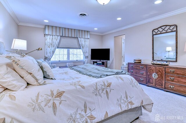 bedroom with ornamental molding and light colored carpet