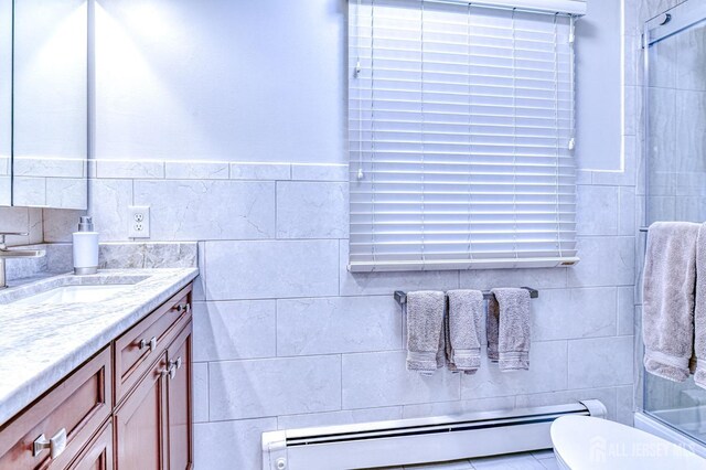 bathroom featuring toilet, baseboard heating, a shower with shower door, and vanity