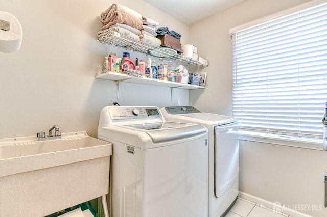 washroom featuring sink, washer and clothes dryer, and light tile patterned floors