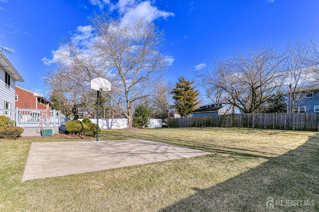 view of yard featuring basketball hoop and a deck