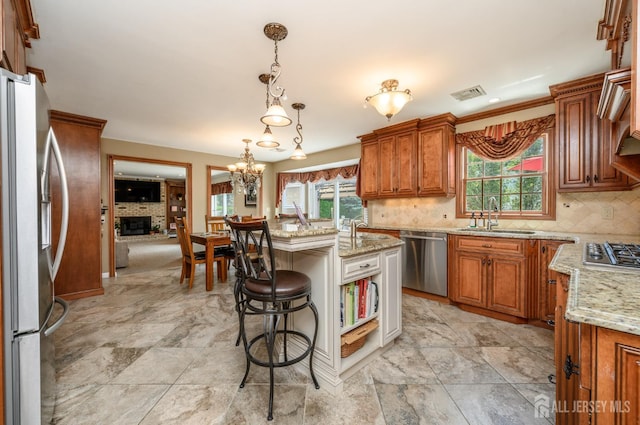 1 Wilfred Rd, Manalapan, NJ 07726 - kitchen featuring appliances with stainless steel finishes, brown cabinetry, healthy amount of natural light, and a kitchen breakfast bar