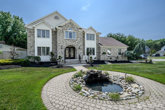 1 Wilfred Rd, Manalapan, NJ 07726 - view of front of house with a front lawn, brick siding, and a small pond