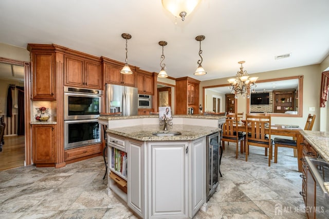 1 Wilfred Rd, Manalapan, NJ 07726 - kitchen with stainless steel appliances, wine cooler, a chandelier, brown cabinets, and a kitchen island
