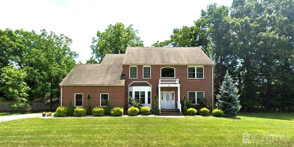 7 Rupprecht Rd, North Brunswick, NJ 08902 - view of front facade featuring a front yard, brick siding, and a balcony