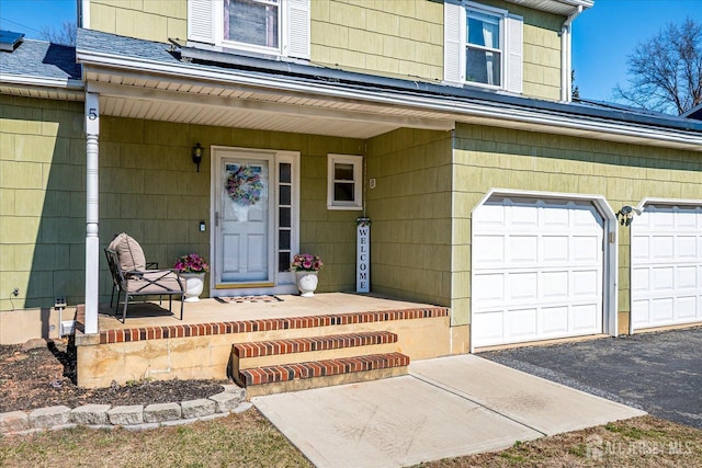 property entrance with roof with shingles, a porch, and driveway