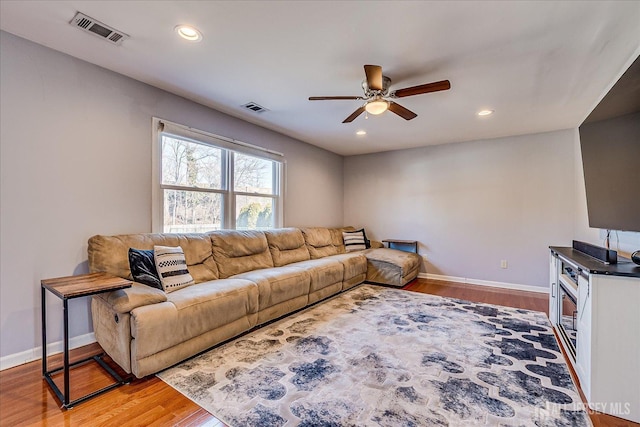 living area with visible vents, light wood-type flooring, and baseboards