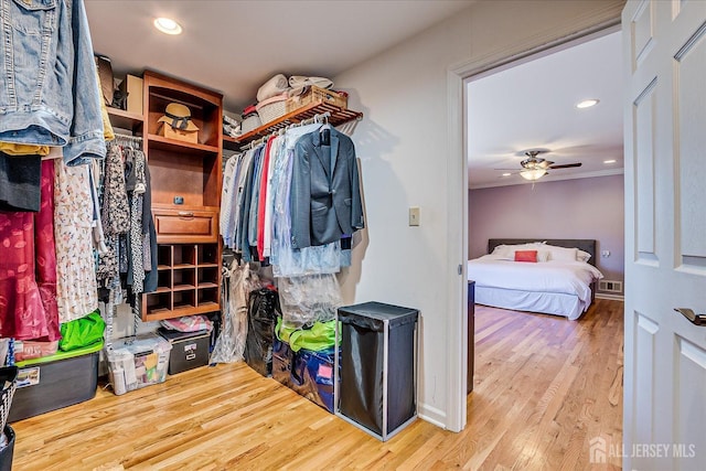 spacious closet featuring visible vents, ceiling fan, and wood finished floors