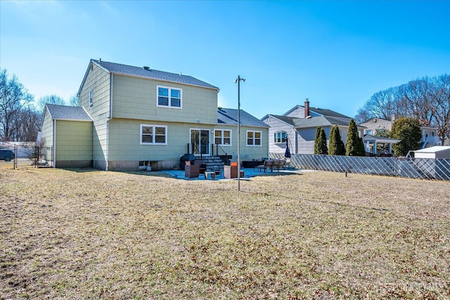 rear view of property featuring entry steps, a patio area, a yard, and fence