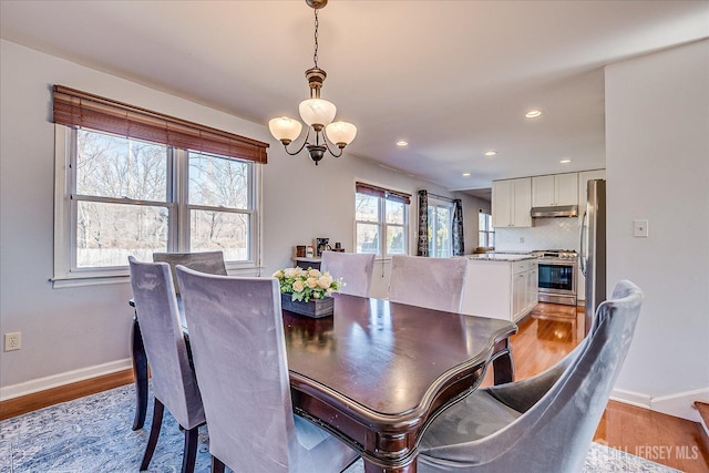 dining room with an inviting chandelier, recessed lighting, baseboards, and light wood finished floors