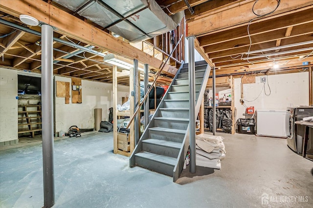 unfinished basement featuring fridge, washer / dryer, and stairs