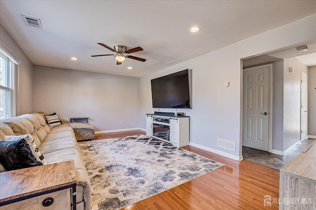 living area featuring recessed lighting, wood finished floors, visible vents, and baseboards