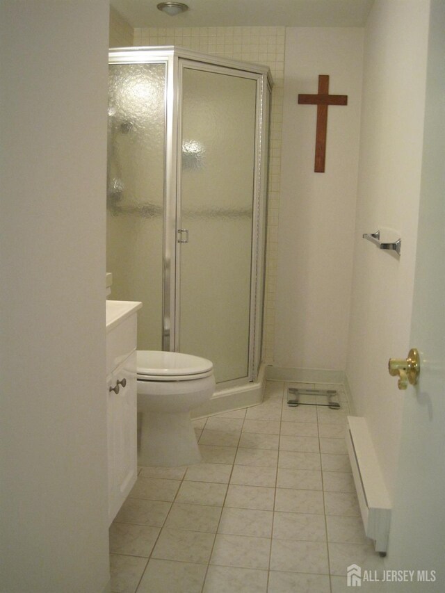 full bathroom with toilet, a stall shower, vanity, baseboards, and tile patterned floors