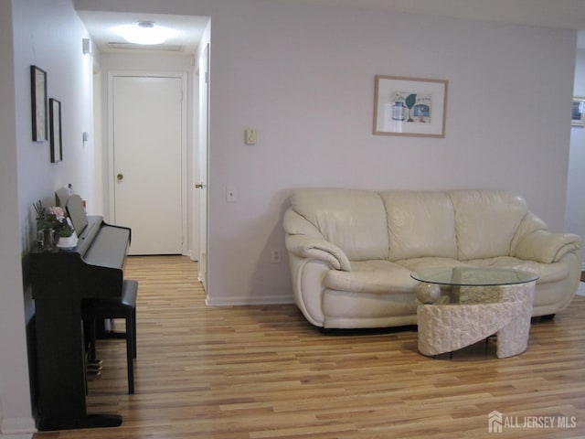 living area featuring light wood-type flooring and baseboards