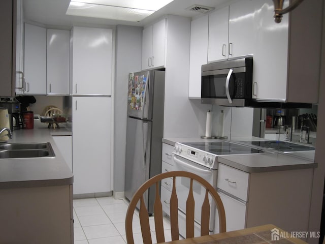 kitchen featuring stainless steel appliances, visible vents, white cabinets, a sink, and light tile patterned flooring