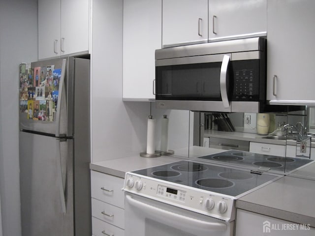 kitchen with stainless steel appliances, white cabinets, and a sink