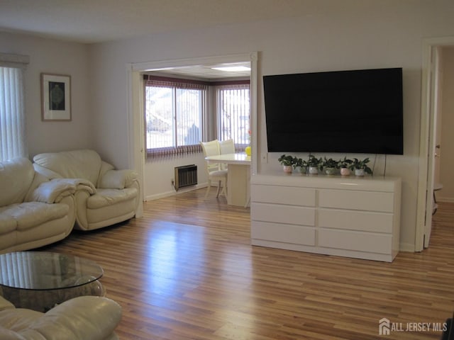 living room with light wood-type flooring and baseboards