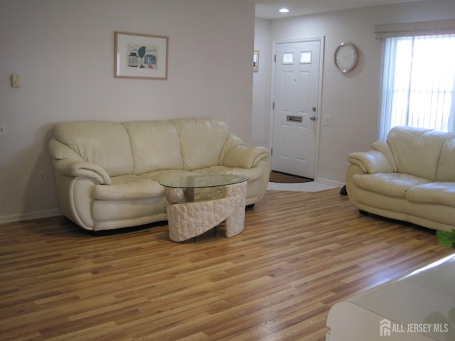 living room with light wood-type flooring, baseboards, and recessed lighting