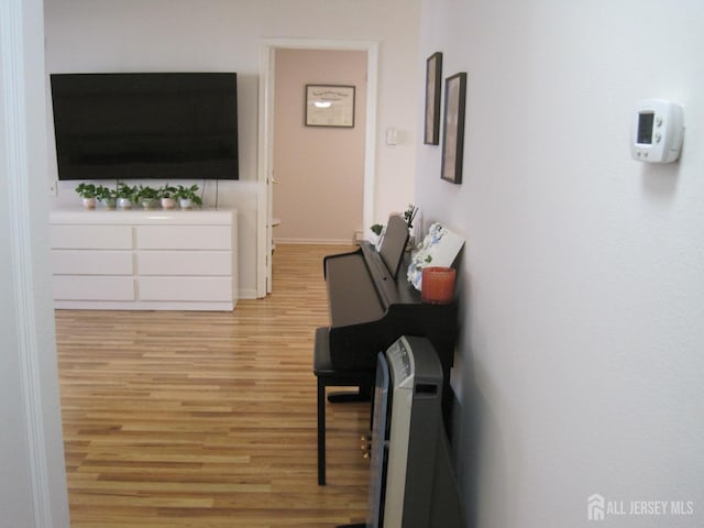 corridor with light wood-style floors and baseboards