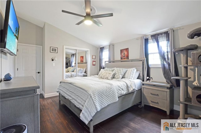 bedroom with multiple windows, dark wood finished floors, a closet, vaulted ceiling, and ceiling fan