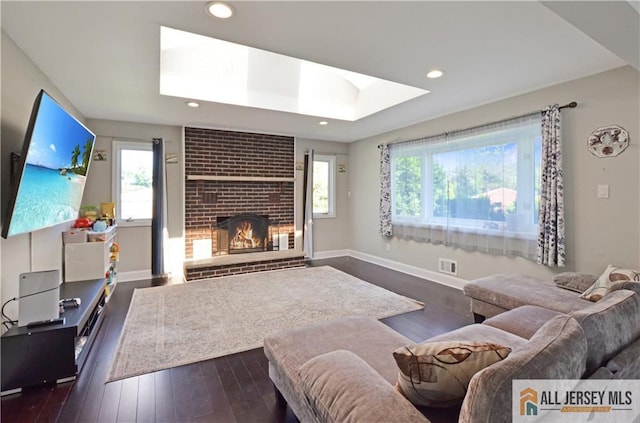 living room featuring dark wood-style flooring, healthy amount of natural light, and recessed lighting