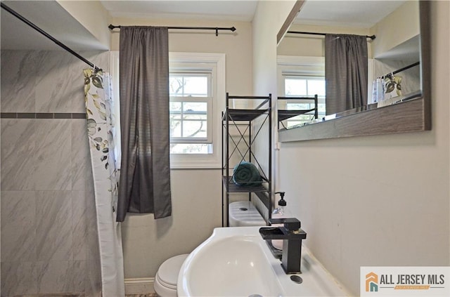 full bath with plenty of natural light, a sink, toilet, and curtained shower