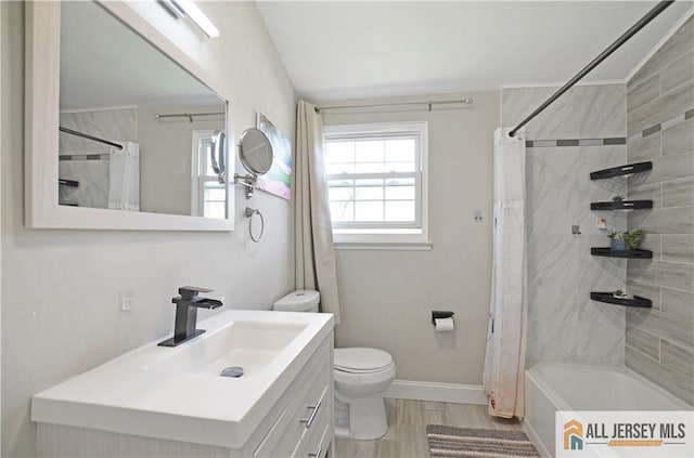 full bathroom featuring toilet, baseboards, vanity, and shower / tub combo