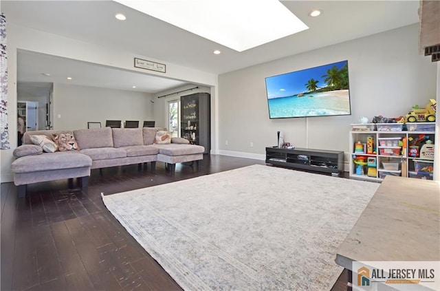 living room with a skylight, dark wood-type flooring, recessed lighting, and baseboards