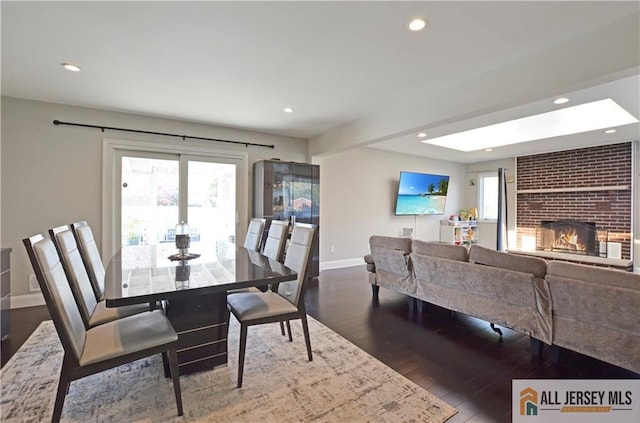 dining area with recessed lighting, baseboards, wood finished floors, and a fireplace