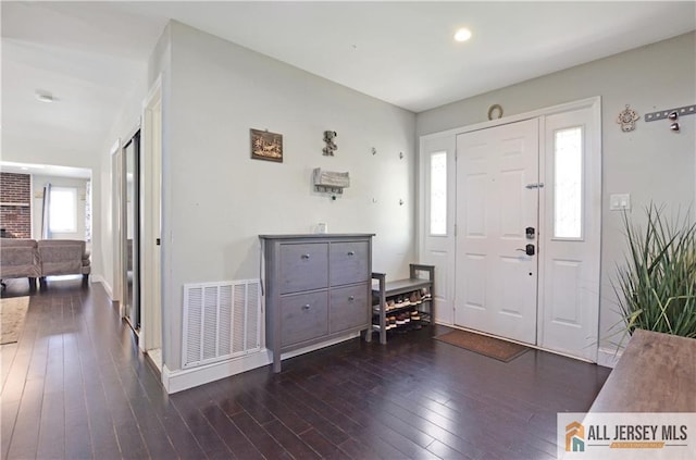 entrance foyer featuring plenty of natural light, wood-type flooring, and baseboards