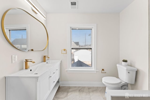 bathroom featuring plenty of natural light, visible vents, and a sink