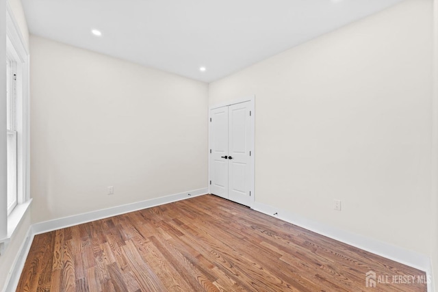 unfurnished room with recessed lighting, baseboards, and wood finished floors