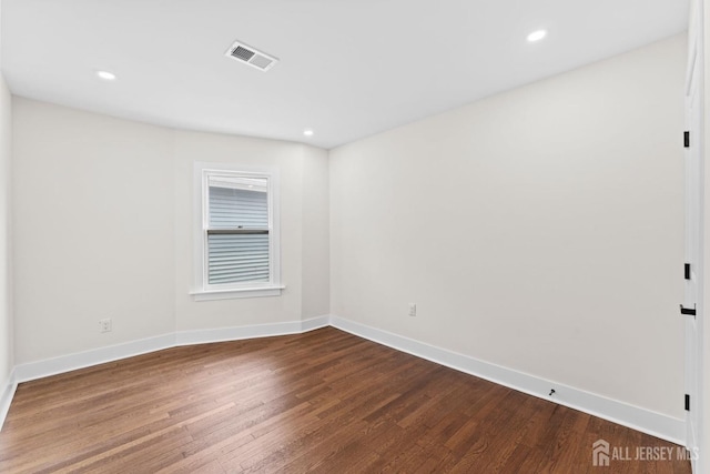 empty room featuring recessed lighting, baseboards, visible vents, and dark wood-style flooring