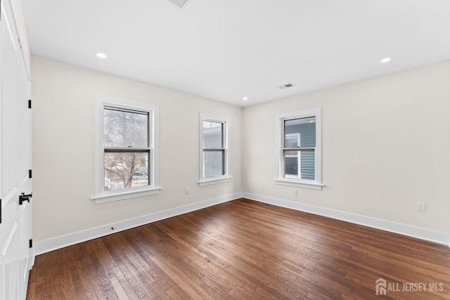 spare room featuring hardwood / wood-style floors, visible vents, recessed lighting, and baseboards