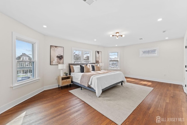 bedroom with recessed lighting, multiple windows, wood finished floors, and baseboards