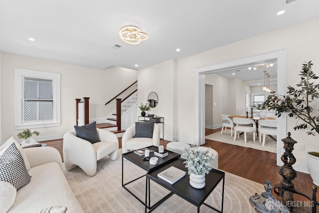 living area with visible vents, baseboards, stairway, recessed lighting, and wood finished floors