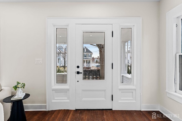 doorway featuring baseboards and dark wood-style floors