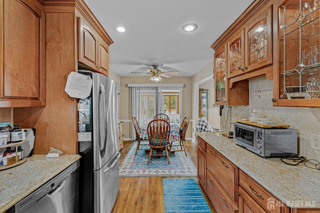 309 Sharon Way Unit A, Monroe, NJ 08831 - kitchen featuring a toaster, stainless steel appliances, backsplash, glass insert cabinets, and light wood-style flooring