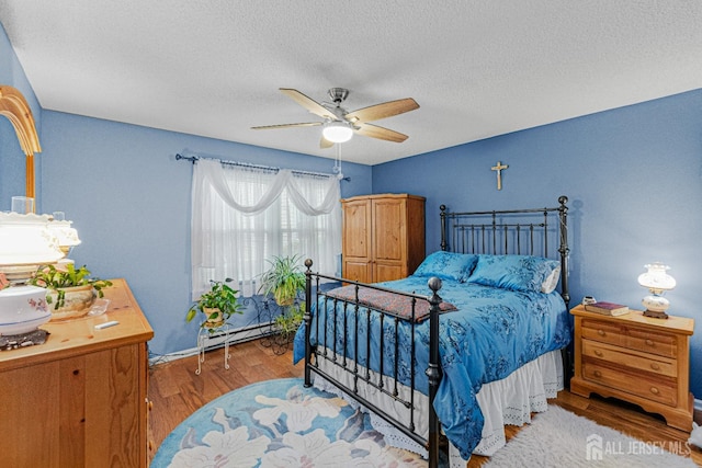 309 Sharon Way Unit A, Monroe, NJ 08831 - bedroom featuring baseboard heating, wood finished floors, ceiling fan, and a textured ceiling