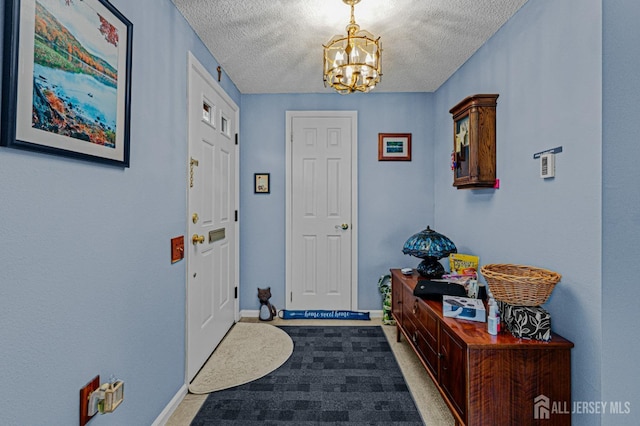309 Sharon Way Unit A, Monroe, NJ 08831 - foyer featuring carpet, baseboards, a textured ceiling, and a notable chandelier