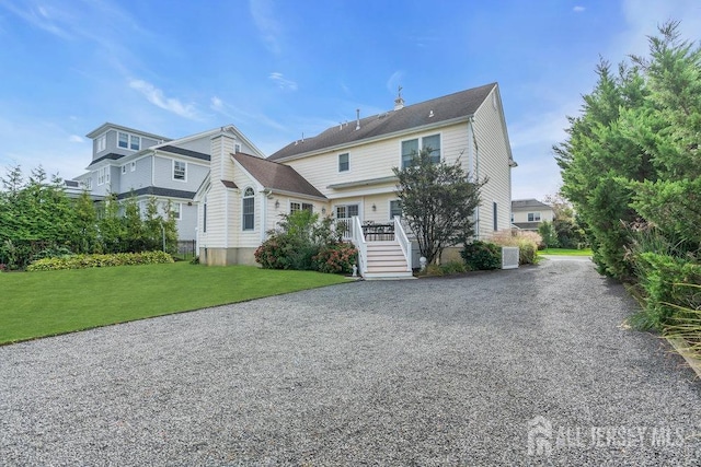 view of front of house featuring gravel driveway and a front lawn