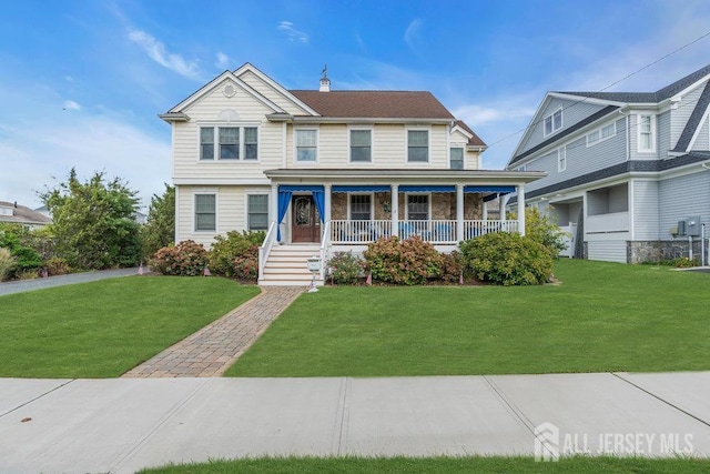 view of front facade with a front lawn, a porch, and stone siding