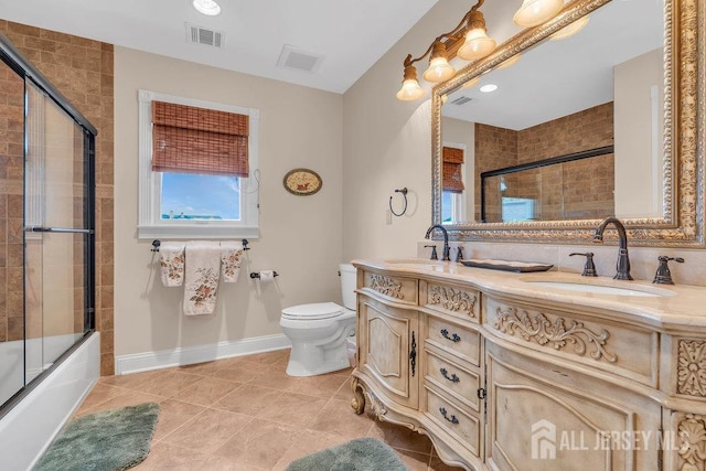 bathroom featuring double vanity, toilet, tile patterned flooring, and a sink
