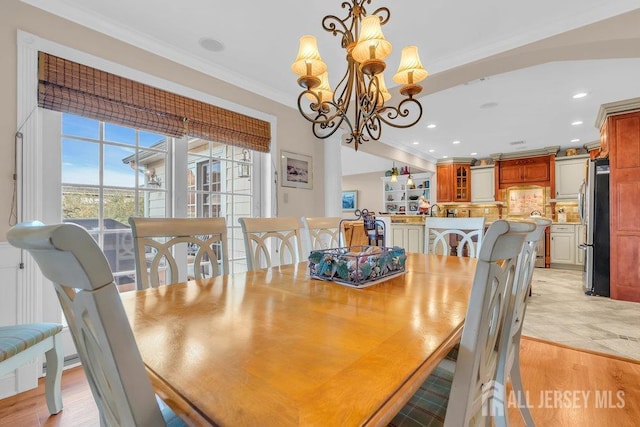 dining space featuring an inviting chandelier, crown molding, and recessed lighting