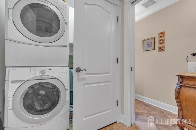 laundry area with stacked washer / dryer, laundry area, visible vents, baseboards, and light tile patterned flooring