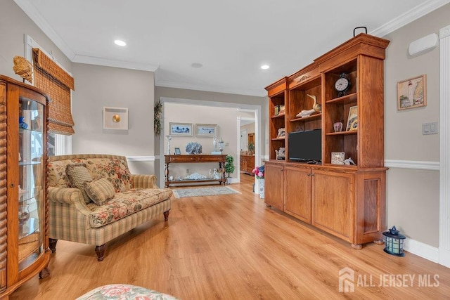 living area with ornamental molding, light wood-style floors, recessed lighting, and baseboards