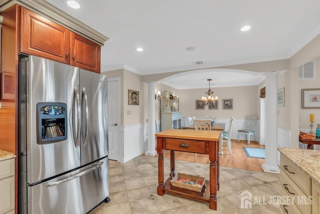 kitchen with ornate columns, stainless steel fridge with ice dispenser, crown molding, visible vents, and arched walkways