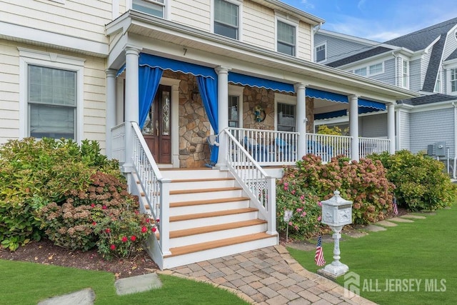 doorway to property featuring stone siding and a porch